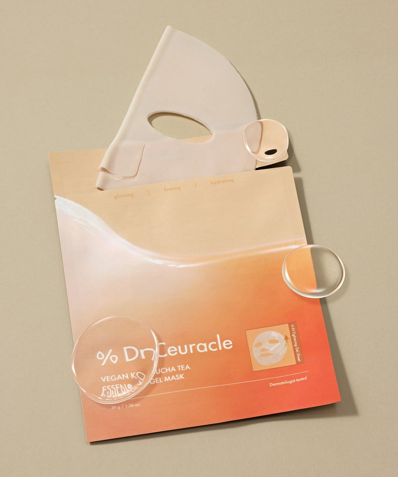 Décris l'image en français : DR.CEURACLE Vegan Kombucha Tea Essence-in-Gel Mask, marque sur masque en gel, posé sur fond beige.