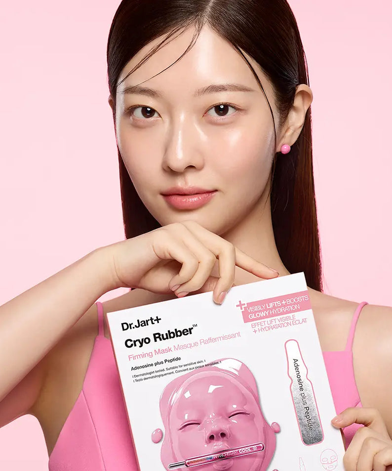 Décris l'image en français : DR.JART+ Cryo Rubber Masks 4 Types, masque et pack, visage d'une femme sur fond rose.