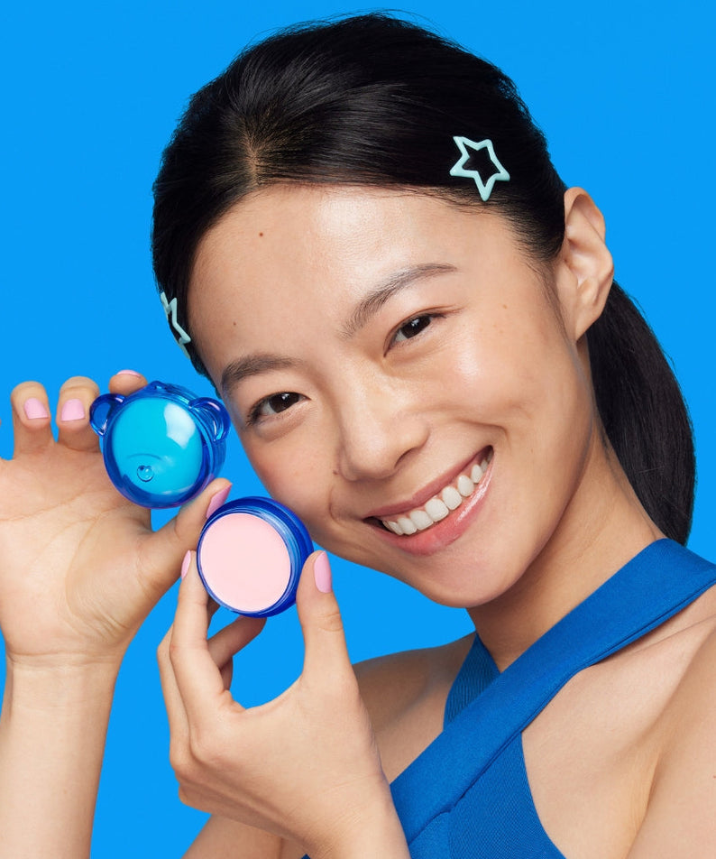 Décris l'image en français : DR.JART+ Vital Hydra Solution™ Hydrating Lip Mask, marque présentée sur fond bleu avec produit et visage.