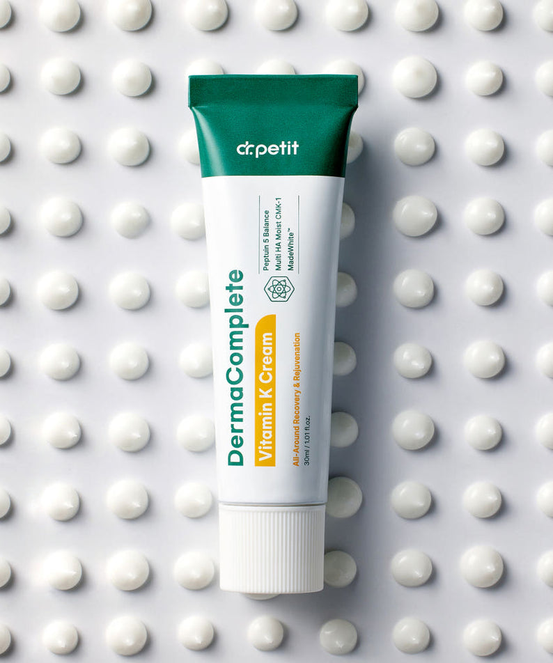 DR.PETIT Derma Complete Vitamin K Cream 30ml de marque Dr.Petit, tube sur fond à pois blancs, contexte beauté.
