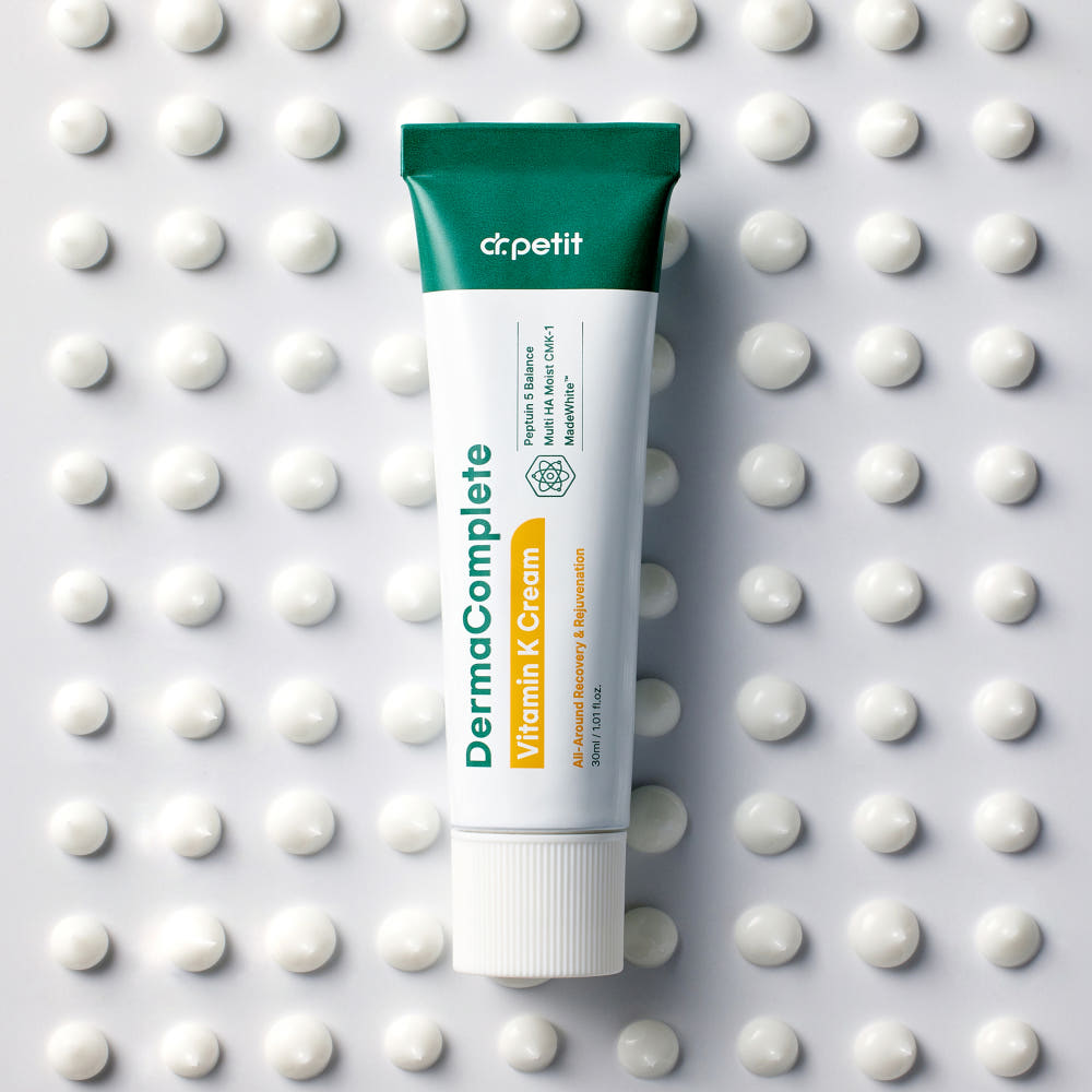 DR.PETIT Derma Complete Vitamin K Cream 30ml de marque Dr.Petit, tube sur fond à pois blancs, contexte beauté.