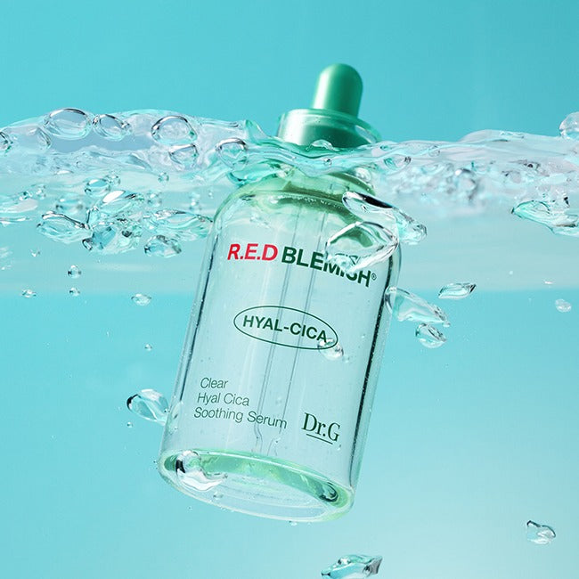 Dr.G Red Blemish Clear Hyal Cica Soothing Serum 50ml en flacon, marque Dr.G, dans des gouttes d’eau sur fond bleu.
