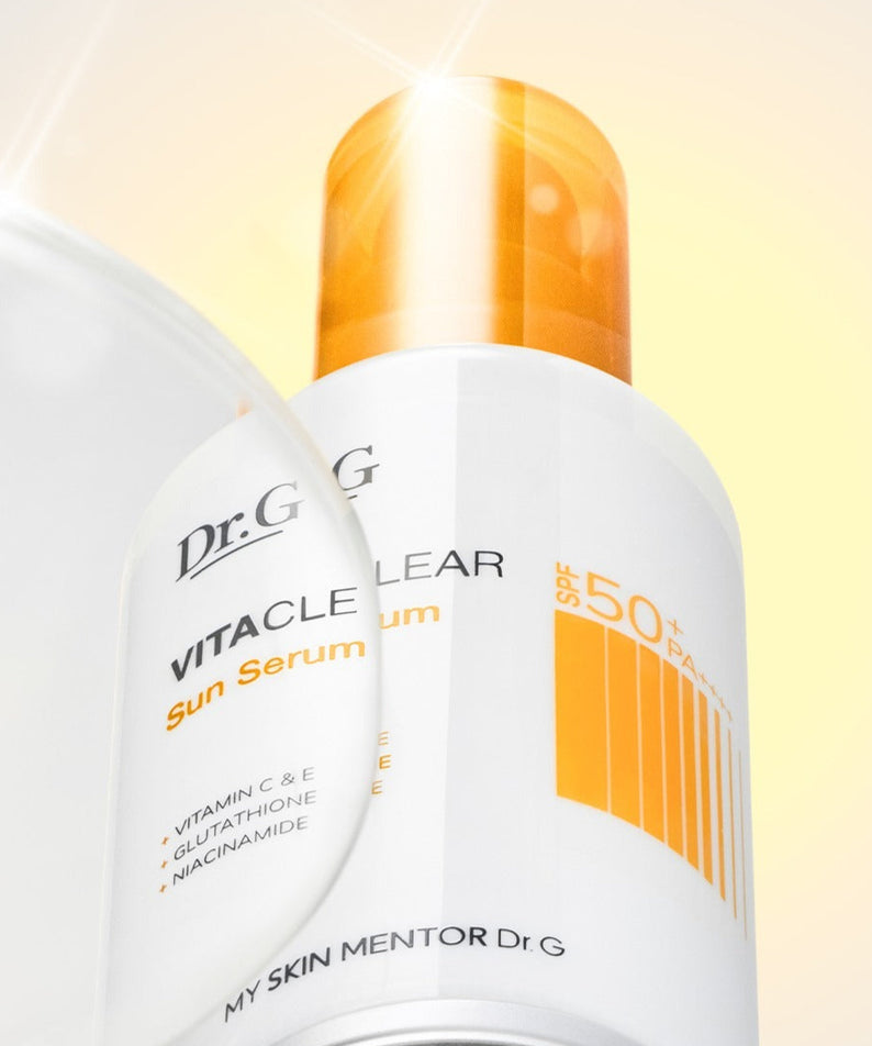 Décris l'image en français : Dr.G Vita Clear Sun Serum 50ml, flacon blanc et jaune Dr.G, contexte ensoleillé sur fond crème.