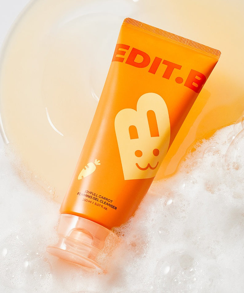 EDIT.B Joyful Carrot Foaming Gel Cleanser 150ml de la marque EDIT.B, tube orange sur mousse blanche, contexte soin visage