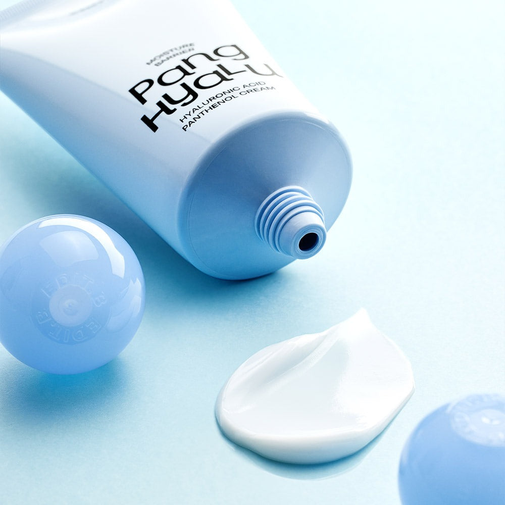 EDIT.B Moisture Barrier Pang Hyaluronic Acid Pathenol Cream 100ml, tube bleu et crème blanche sur fond clair, contexte cosmétique.