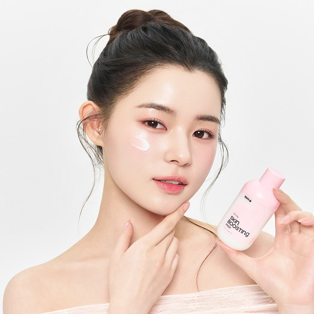 EDIT.B Veil On Skin Boosthing Prep 50ml, flacon rose brandé, modèle peau lumineuse sur fond clair.
