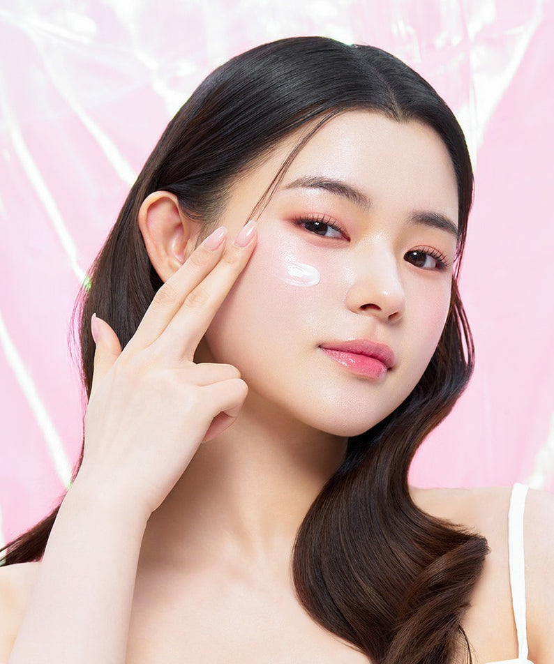 EDIT.B Veil On Skin Boosthing Prep 50ml, soin marque EDIT.B sur peau de femme, crème appliquée, fond rose lumineux.
