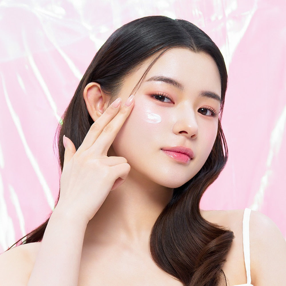 EDIT.B Veil On Skin Boosthing Prep 50ml, soin marque EDIT.B sur peau de femme, crème appliquée, fond rose lumineux.