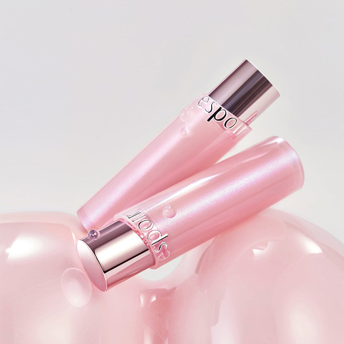 ESPOIR Bare Glow Lip Balm : baume lèvres rose brillant, packaging rose argent sur fond blanc, produit cosmétique