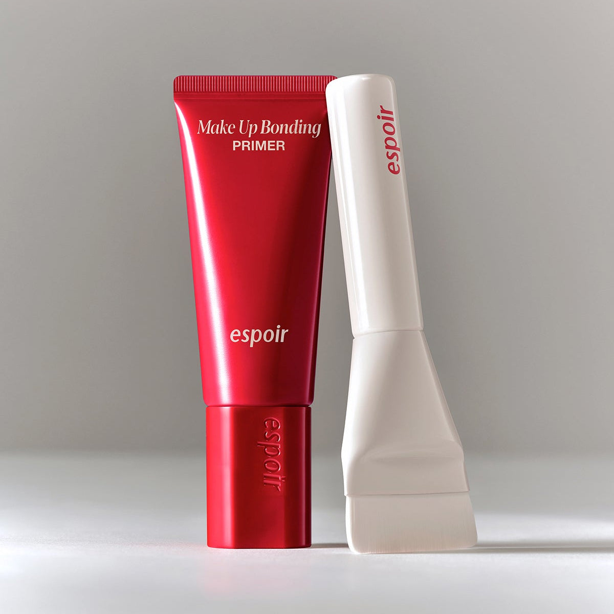 ESPOIR Make Up Bonding Primer, tube rouge et blanc sur fond clair, amorce maquillage de la marque espoir en studio.