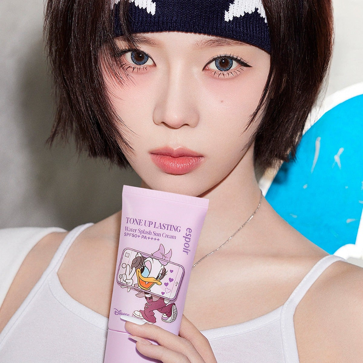 ESPOIR Water Splash Sunscreen Tone Up Lasting [Disney Edition] sur une femme, branding Disney et dégradé violet, effet tone up.