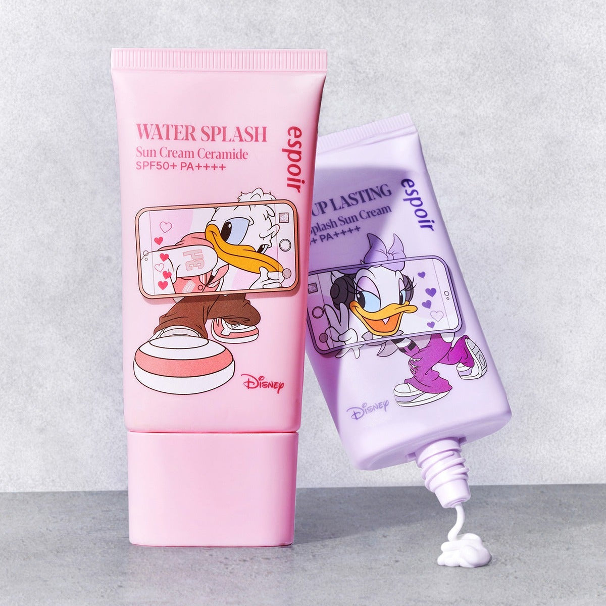 ESPOIR Water Splash Sunscreen Tone Up Lasting [Disney Edition] : tubes rose et violet Disney, crème SPF sur fond clair.