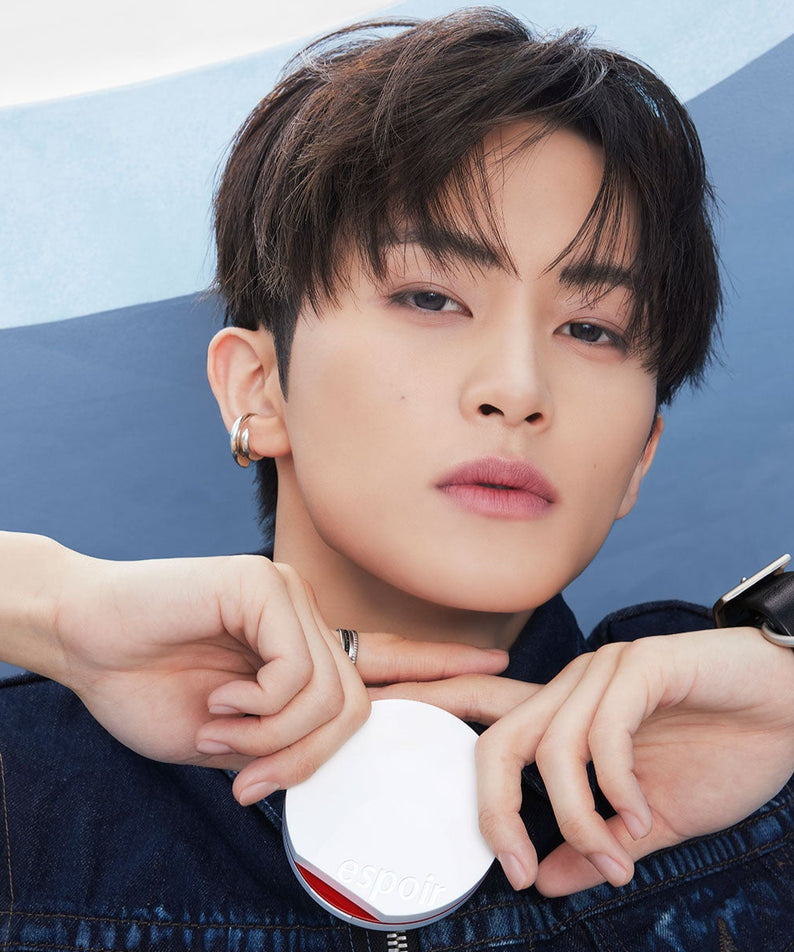 Portrait d'un mannequin avec un produit ESPOIR Bevelvet Sebumcut Cooling Cushion, style moderne et élégant, fond bleu.