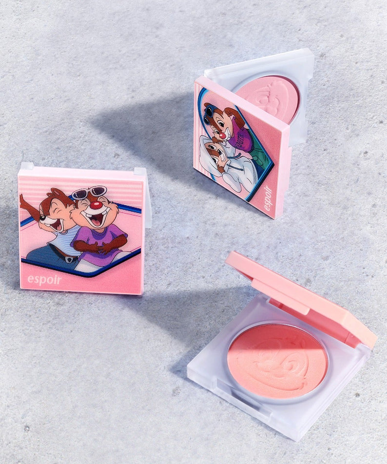 Boîtier de maquillage ESPOIR Blurry Cheek [Disney Edition] sur surface grise, mettant en avant la collaboration Disney. Parfait pour un look vif.