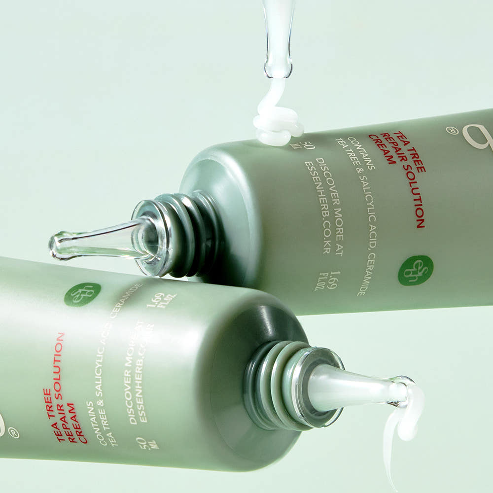 ESSENHERB Tea Tree Repair Solution Cream 50ml, tube vert avec gouttes de crème, marque ESSENHERB sur fond clair.