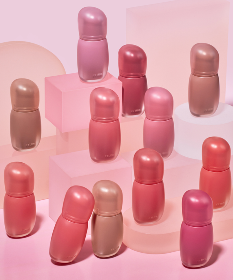ETUDE  Cozy Fixing Tint 4g, tubes maquillage de la marque ETUDE, sur socles rose pastel, déco beauté.