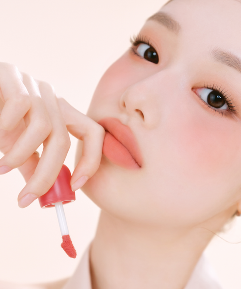 ETUDE Cozy Fixing Tint 4g : femme applique un tint teint lèvres, photo beauté sur fond clair.