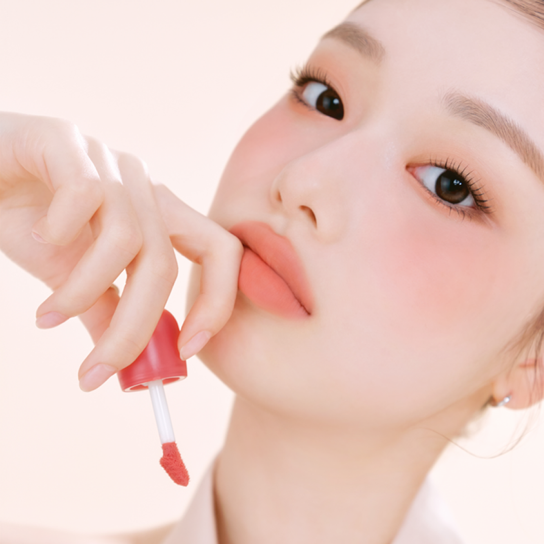ETUDE Cozy Fixing Tint 4g : femme applique un tint teint lèvres, photo beauté sur fond clair.