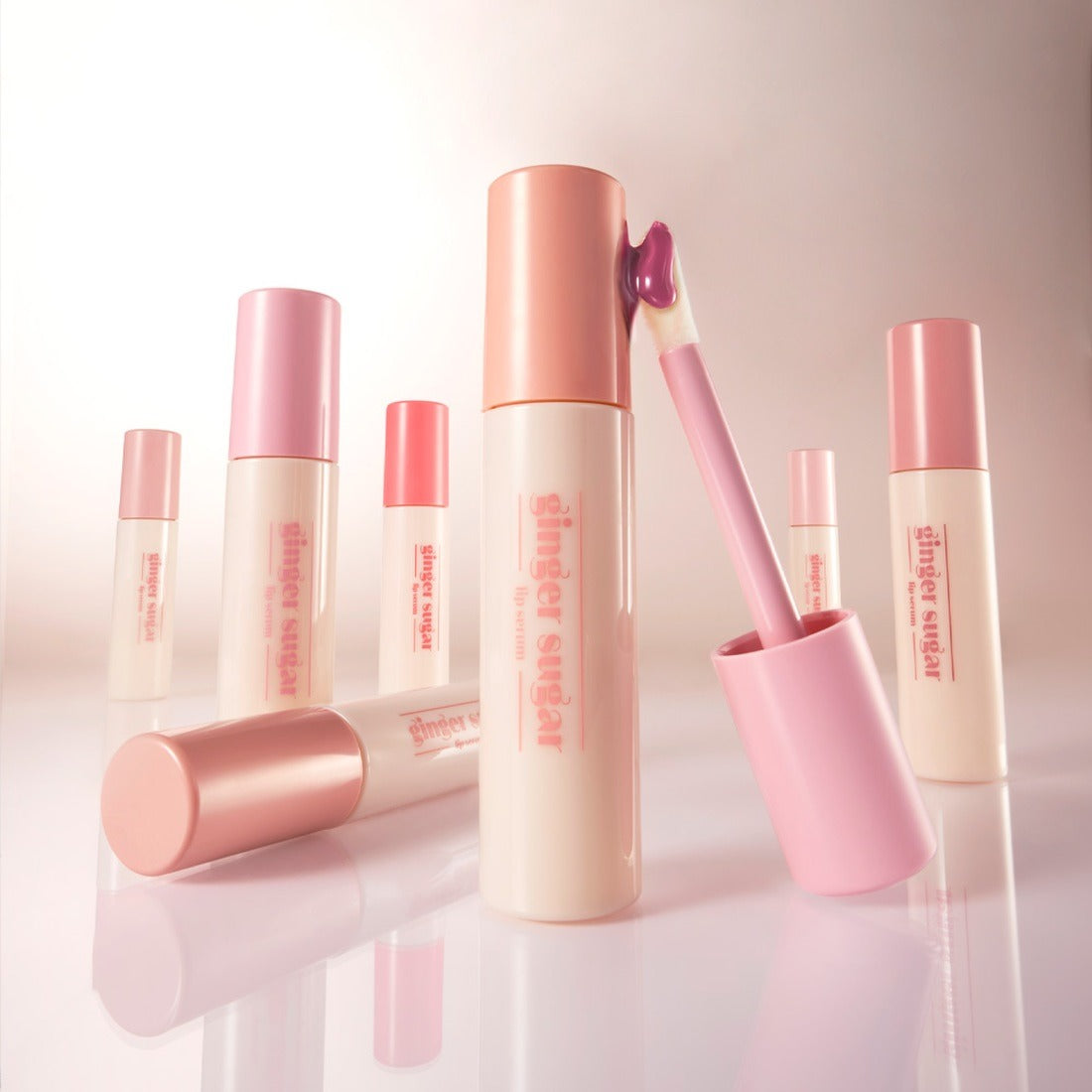 ETUDE Ginger Sugar Lip Serum 13g de la marque ETUDE, présentés en tubes rose avec application de sérum, sur fond clair.