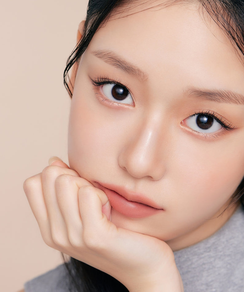Décris l'image en français : close-up maquillage avec ETUDE Re-creation Maker Aegyo-Sal Liner, regard féminin, fond beige.