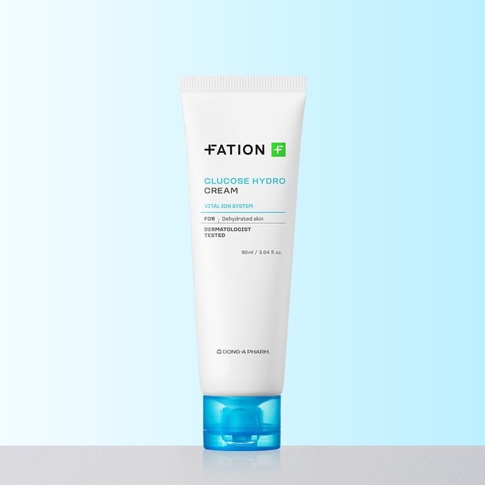 Décris l'image en français : FATION Glucose Hydro Cream 90ml, tube blanc de la marque FATION sur fond bleu.