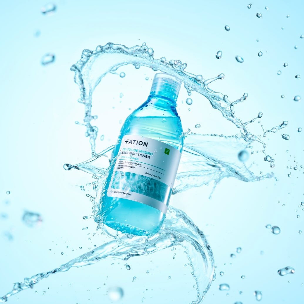 FATION Glucose Hydro Essence Toner 500ml, bouteille FATION avec éclaboussures d’eau, fond bleu, visuel beauté