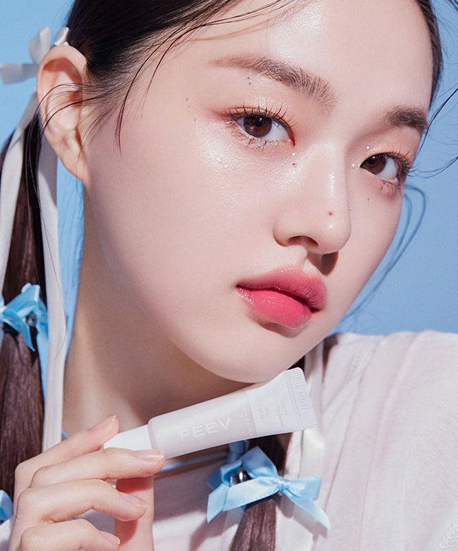 Jeune femme tenant FEEV Hyper-Fit Shimmering Serum pour une peau éclatante et lumineuse.