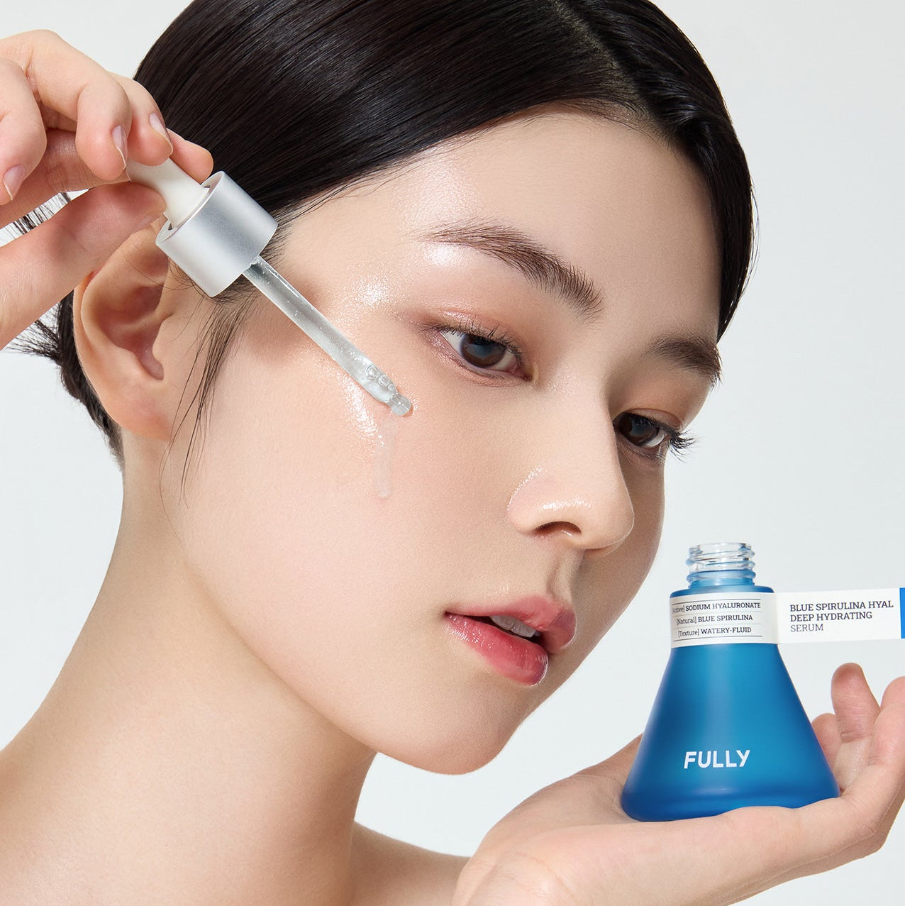 FULLY  Blue Spirulina Hyal Moisture Serum : sérum hydratant sur peau, jeune femme, flacon bleu, main tenant le produit