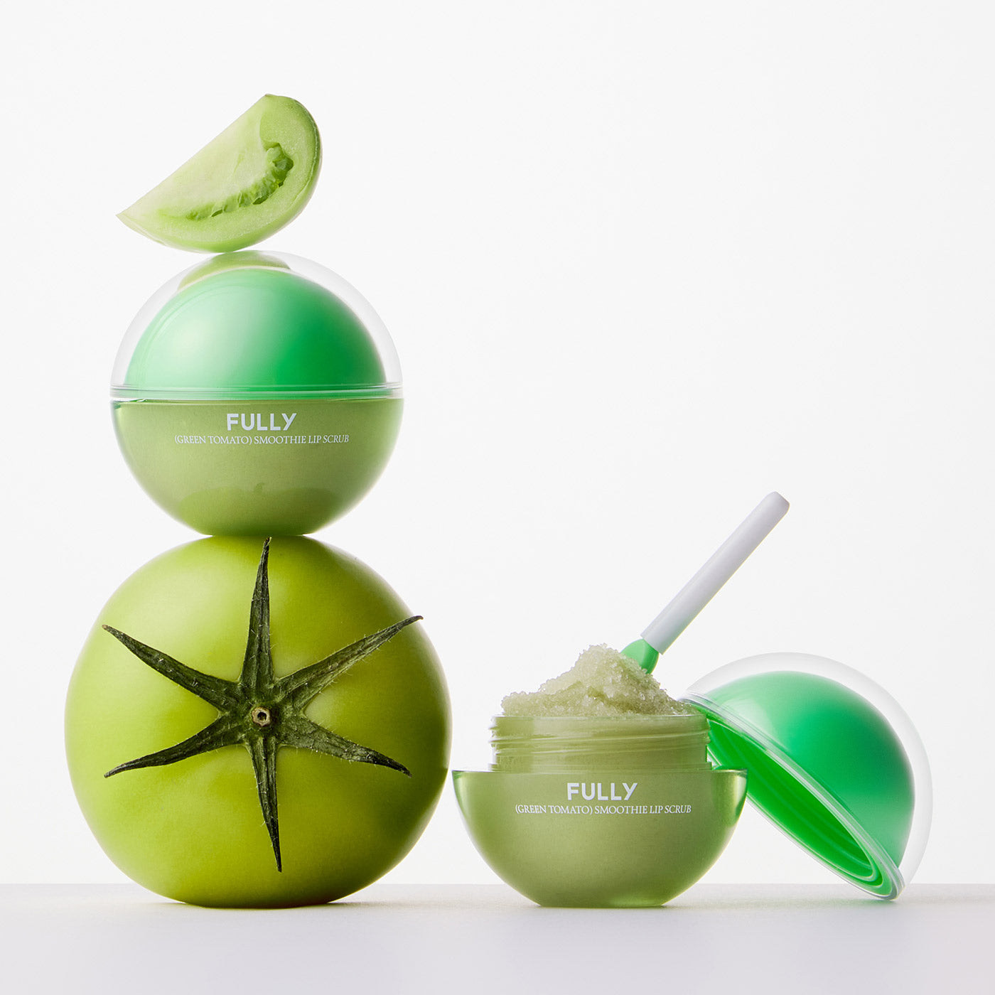 FULLY Green Tomato Smoothie Lip Scrub 12g de marque FULLY, lèvres en texture verte et décor tomate, fond blanc