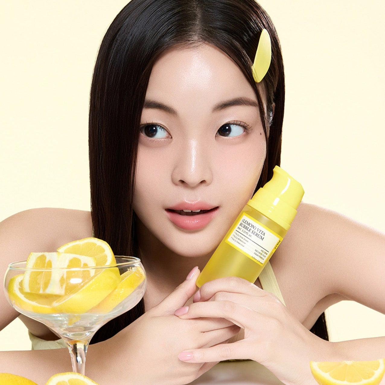FULLY  Lemon Vita Bubble Serum 95ml de la marque FULLY, femme au visage souriant tenant le flacon et des citrons en arrière-plan