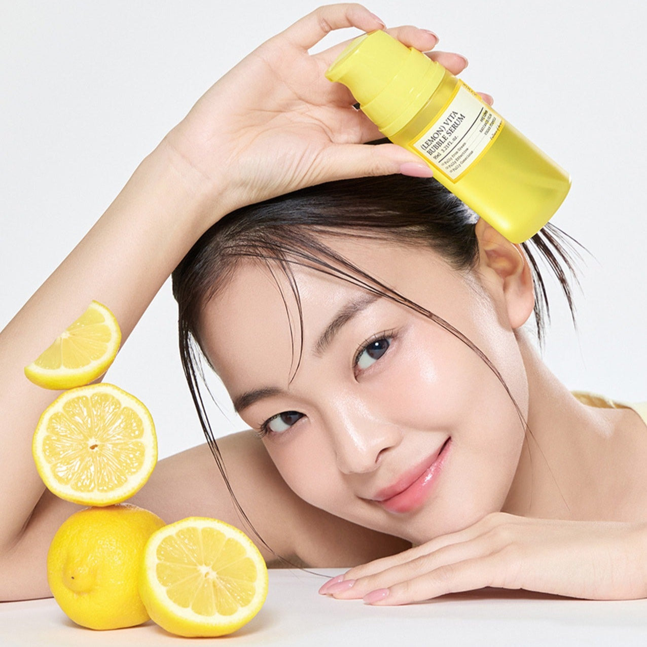 FULLY  Lemon Vita Bubble Serum 95ml de la marque FULLY, visage avec huile citron et mains, décor agrumes sur fond clair