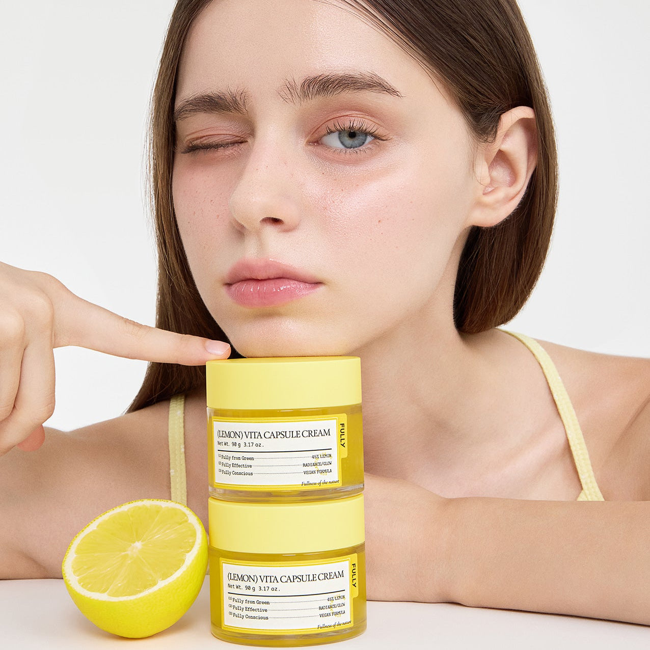 FULLY Lemon Vita Capsule Cream 90g, marque FULLY, crème visage au citron sur fond clair, modèle femme en gros plan.