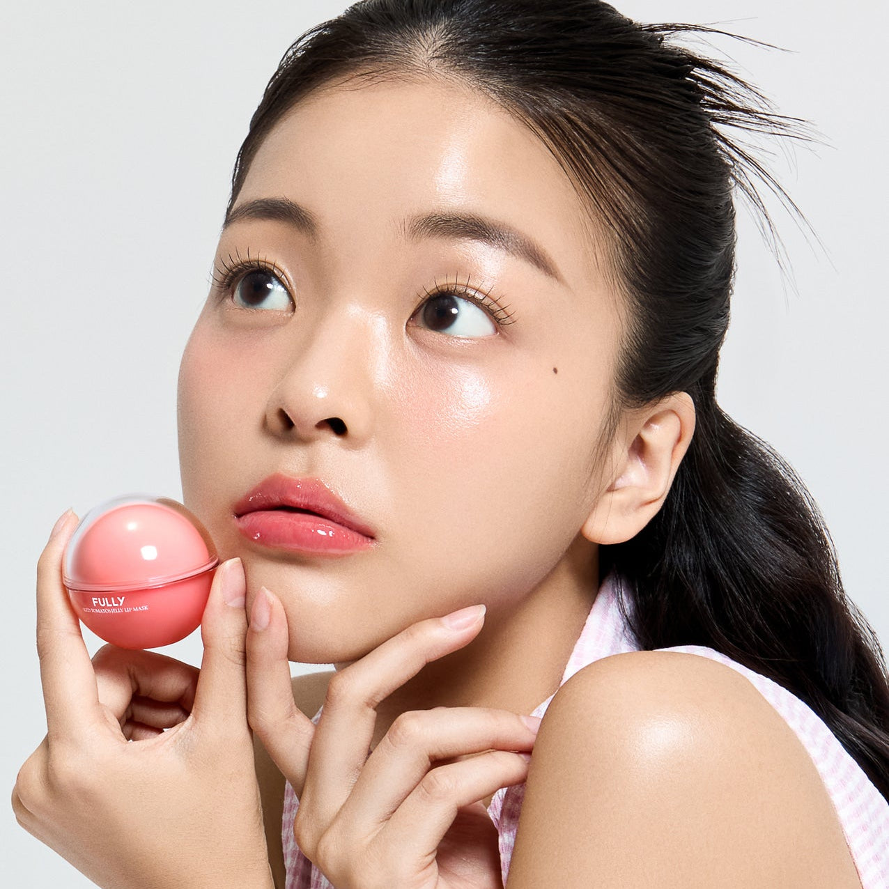 FULLY Red Tomato Jelly Lip Mask 12g de FULLY, pot rouge tenu par une femme, lèvres hydratées, fond clair
