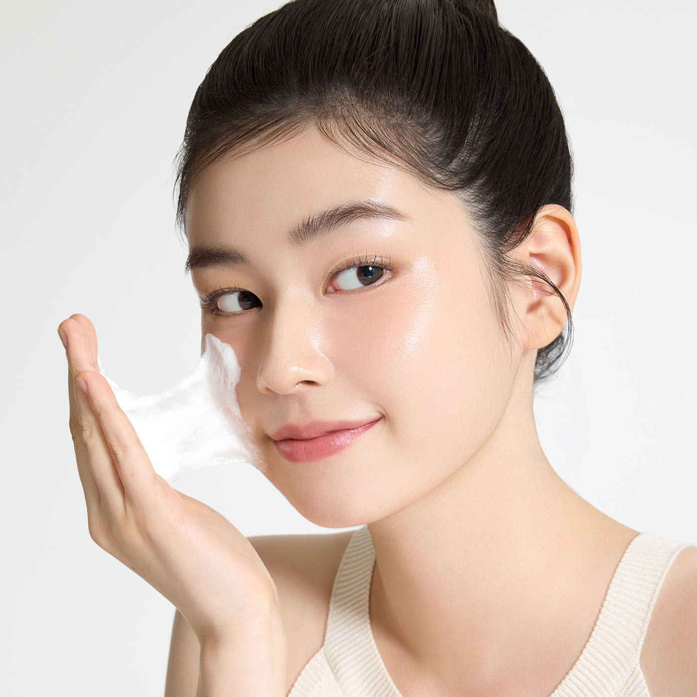 Femme appliquant crème sur le visage, flacon FULLY  Rice Dough Pack Cleanser 130ml, marque FULLY, fond blanc