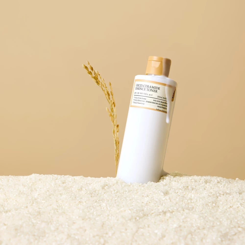FULLY  Rice Serum Essence Toner 250ml, flacon crème sur fond beige, décor riz et texture beauté