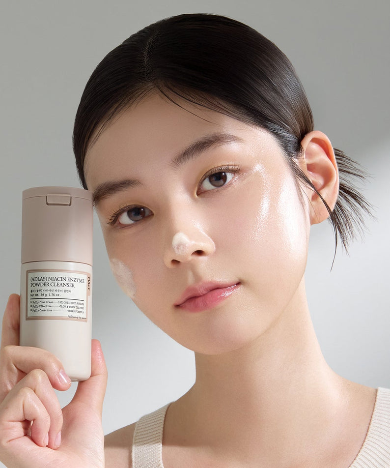 FULLY Yulmu Niacin Enzyme Powder Cleanser 50g de FULLY, flacon tenu par une femme, fond clair, soin visage