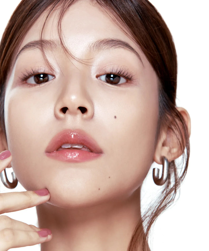 Femme appliquant le FWEE 3D Voluming Gloss pour un effet brillant et volumisant des lèvres.