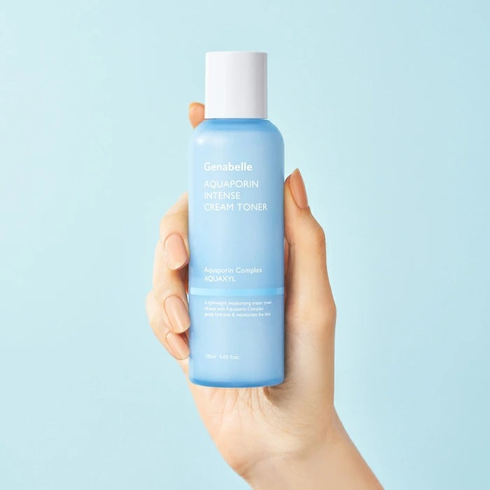 Main tient le flacon GENABELLE Aquaporin Intense Cream Toner 120ml, fond bleu clair, marque GENABELLE
