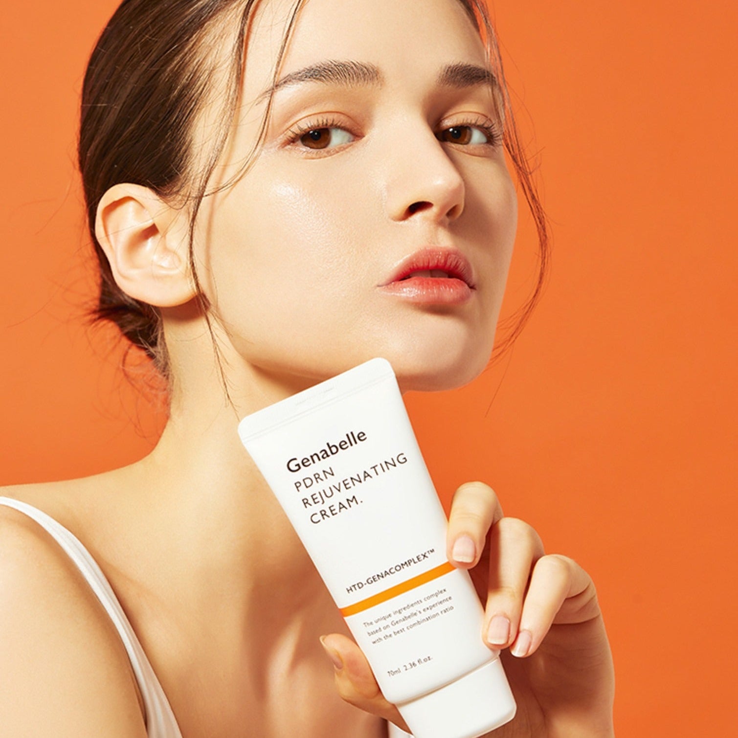 GENABELLE PDRN Rejuvenating Cream 70ml : tube tenu par une femme sur fond orange, application soins visage de Genabelle