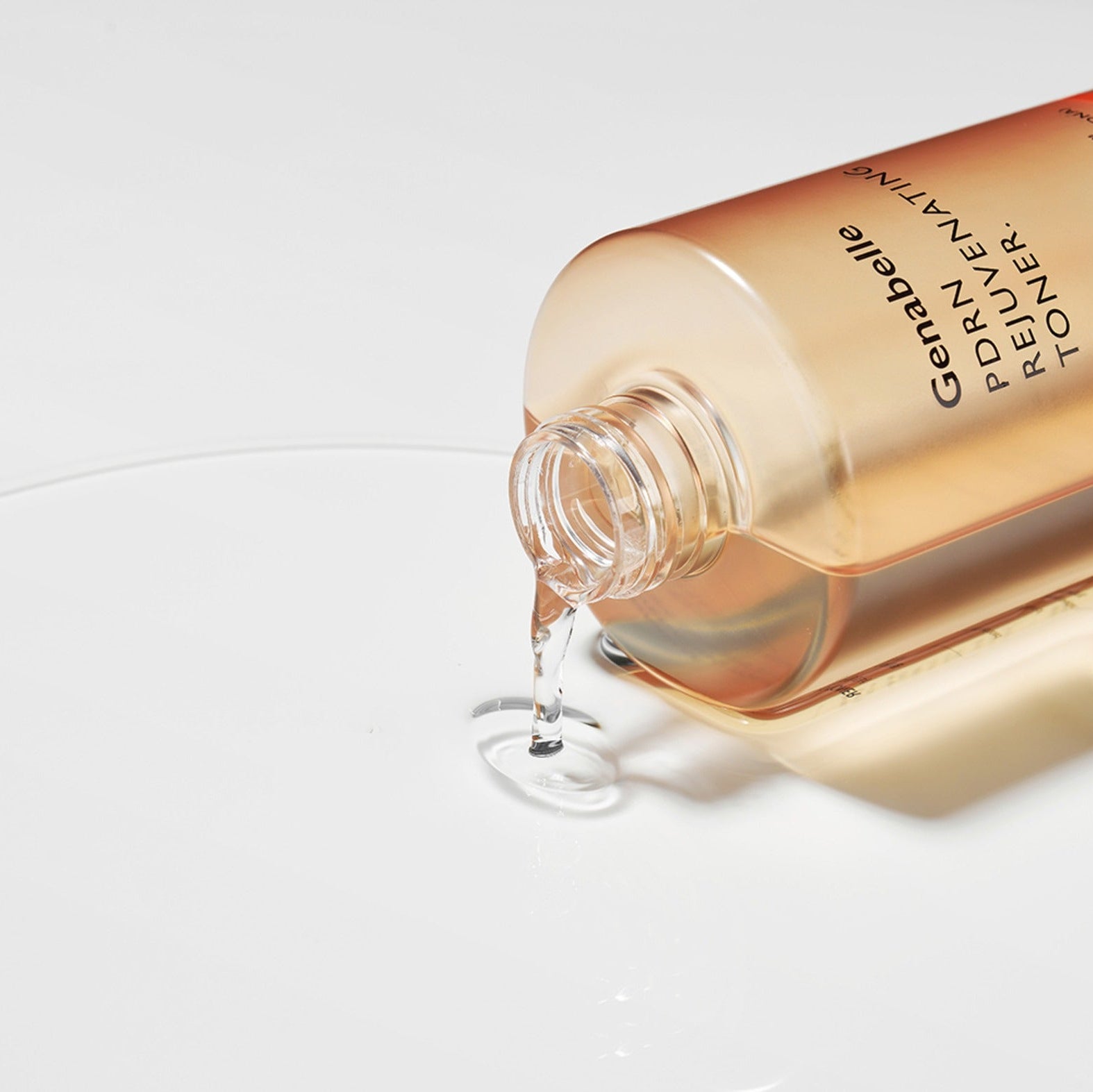 GENABELLE PDRN Rejuvenating Toner 300ml de la marque GENABELLE, flacon doré verse un liquide sur fond blanc