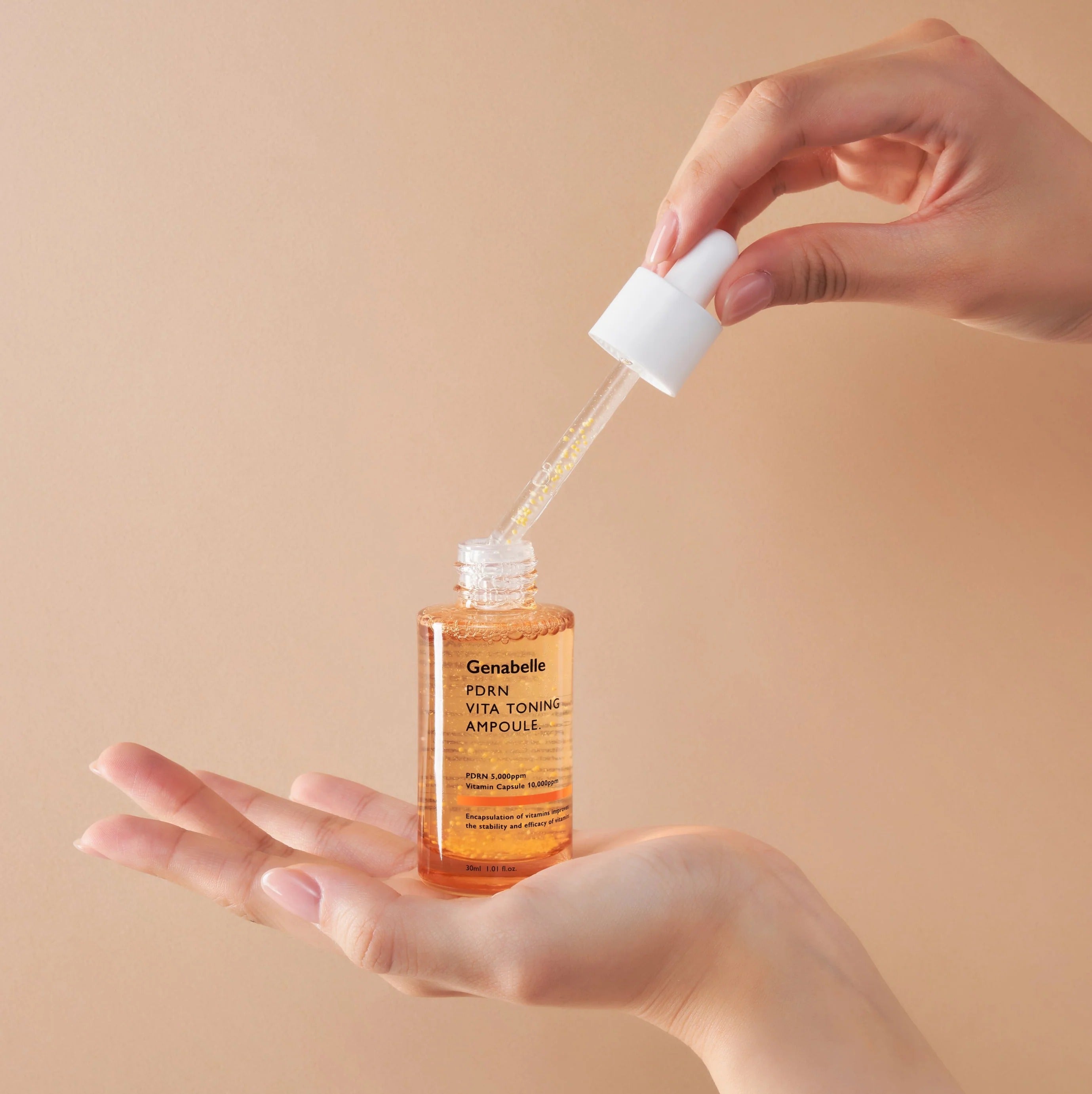 GENABELLE PDRN Vita Toning Ampoule 70ml de Genabelle, mains appliquant un sérum, fond beige, contexte soin visage.