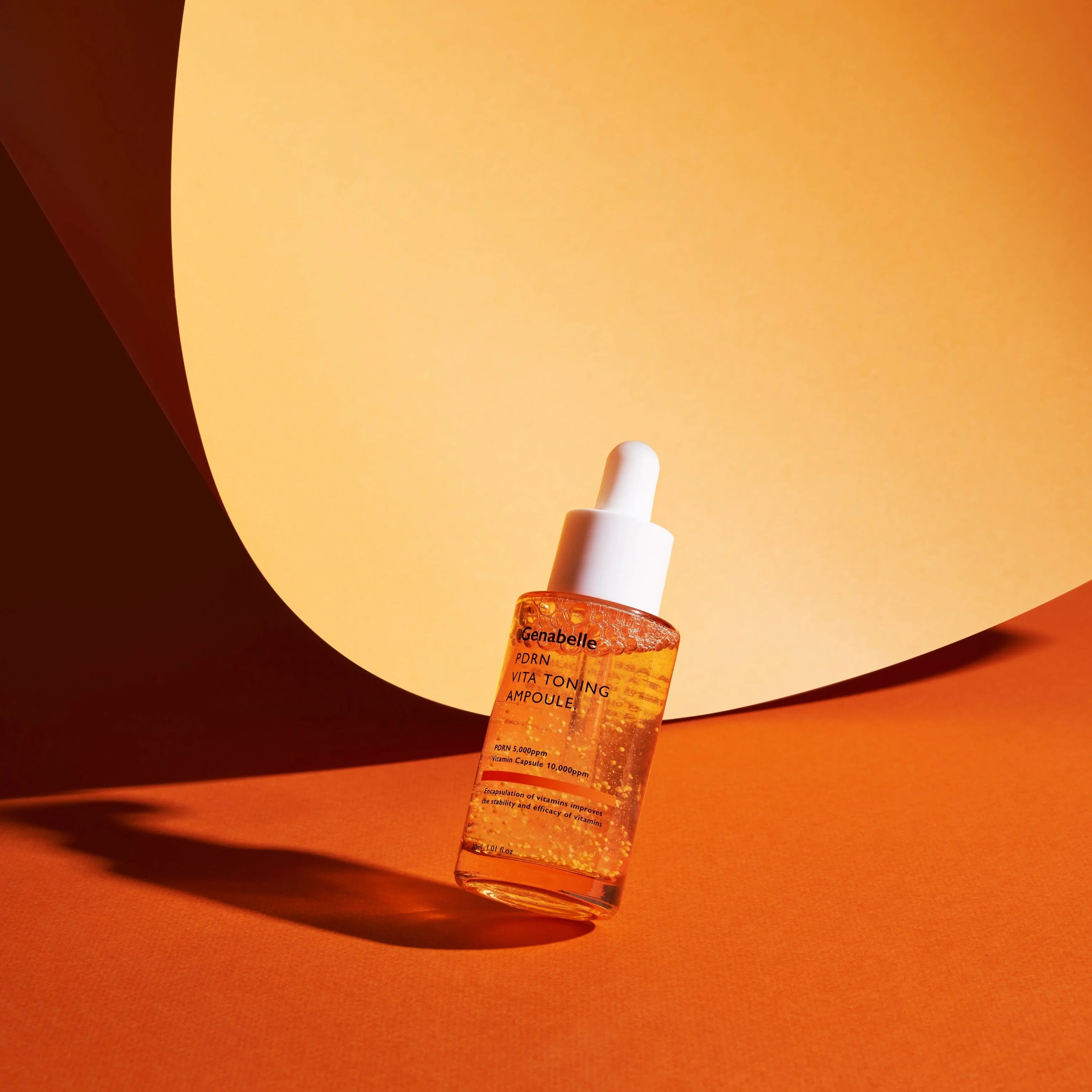 GENABELLE PDRN Vita Toning Ampoule 70ml, flacon sérum éclaircissant sur fond orange, ambiance studio.