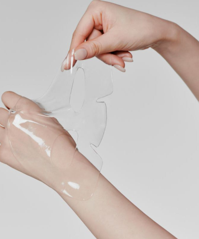 GLOW Aloe Hydrogel Mask Pack 3ea de la marque GLOW sur des mains avec masque hydrogel transparent, fond clair