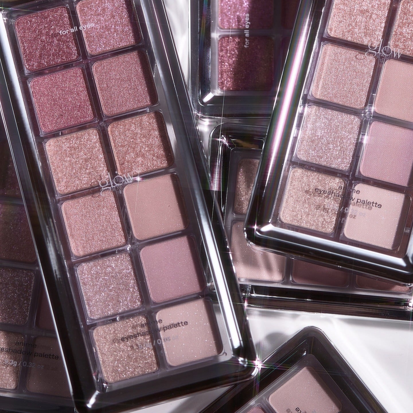 GLOW Anime Eyeshadow Palette, palette de fards brillante en gros plan, ambiances anime, marque GLOW, packaging noir et rose