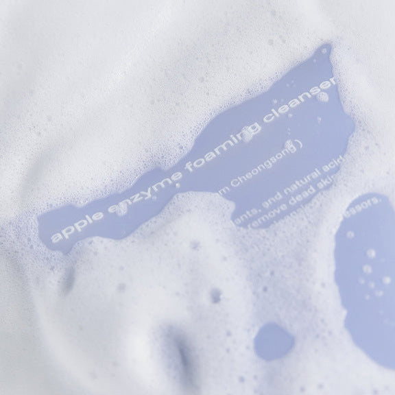 Décris l’image : GLOW Apple Enzyme Cleansing Foam 110g, mousse nettoyante de la marque GLOW sur fond bleu clair.