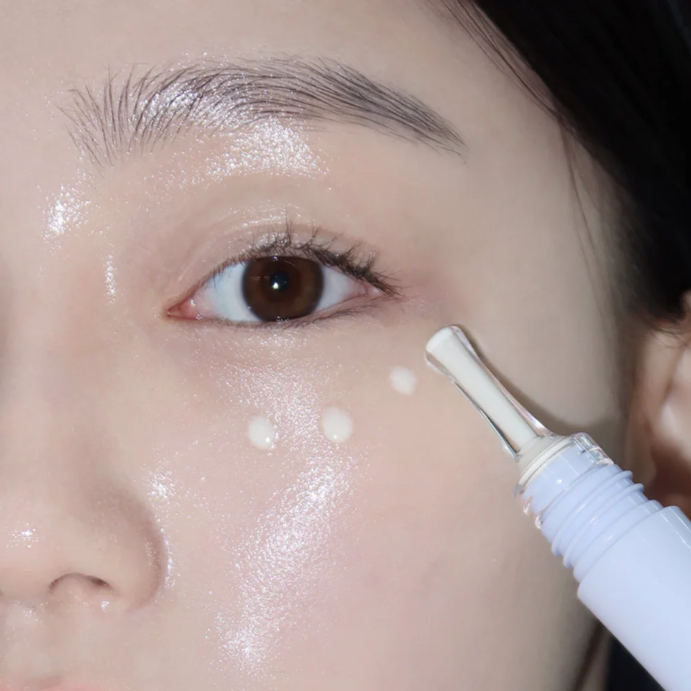 GLOW Apple Retinol Eye Cream 15ml de GLOW, gros plan sur application autour de l’œil, sérum crémeux et visage maquillé