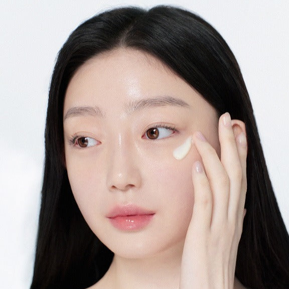 GLOW Apple Retinol Eye Cream 15ml, marque GLOW sur une femme appliquant une crème contour des yeux, fond clair