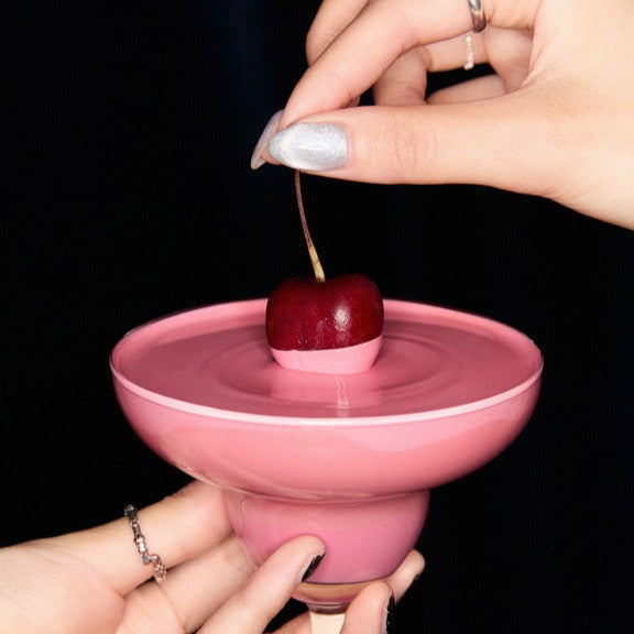 GLOW Cocktail Oil Blusher 7.5g de la marque GLOW, blusher huileux sur un flacon rose, maquillage mains et cerise