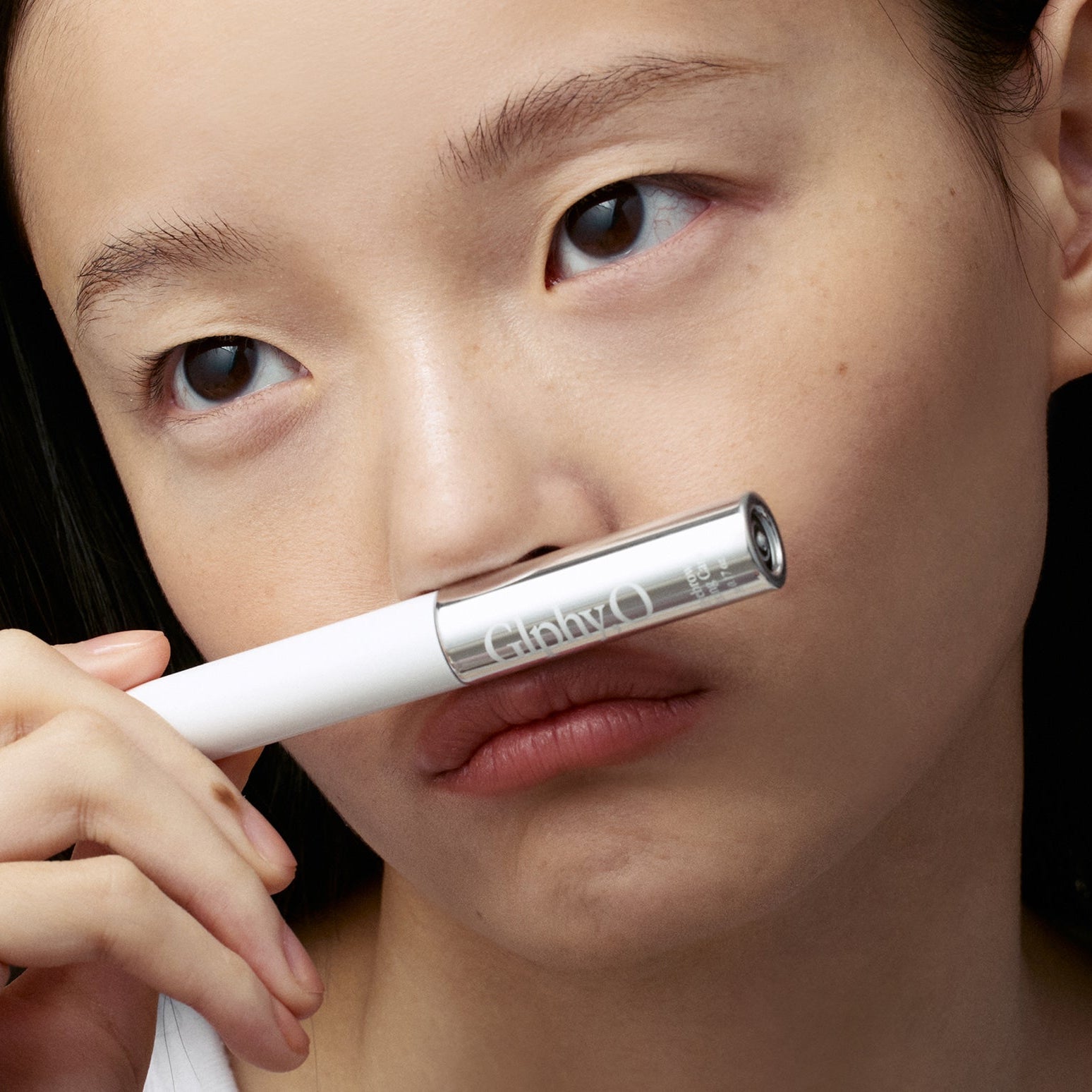 GLPHYO Eyebrow Fixing Cara 5g : femme applique le mascara sur ses sourcils, tube GLPHYO en gros plan.