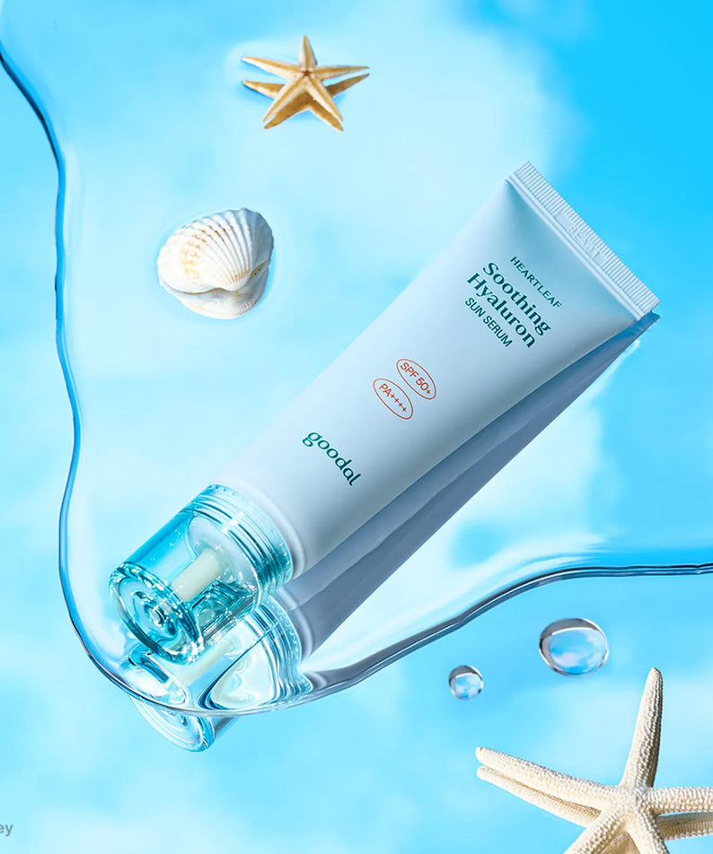Décris l'image en français: GOODAL Eoseongcho Hyaluronic Acid Sun Serum 50ml, tube Goodal sur fond bleu, coquillages et étoile de mer.